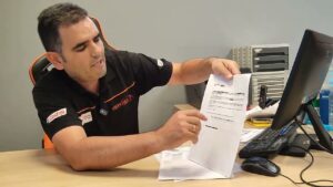 Hombre en oficina señalando y mostrando un documento impreso en papel 5JXs3otHqUw