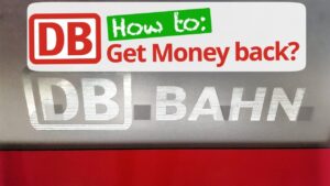 Logo reflectante DB Bahn sobre panel gris y banda roja con etiqueta 'How to: Get Money back?' Plz A 3ymv4.