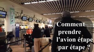 Pasajeros haciendo fila en el área de facturación del aeropuerto con maletas y pantallas de mostrador dSt 1CtJ7DE