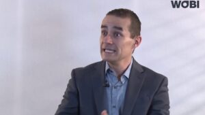 Hombre en traje gesticulando durante una entrevista sobre equipos creativos