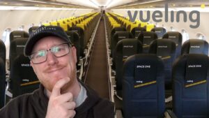 Hombre con gorra y gafas delante de la cabina vacía de Vueling con filas de asientos Space One y Space Plus