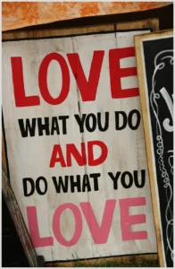 Cartel de madera pintado con las palabras 'Love what you do and do what you love' que transmite motivación y conecta con Teletrabajo por conciliación familiar: Claves para equilibrar tu vida y trabajo.