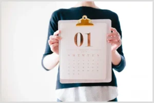 Persona sosteniendo un calendario en un portapapeles con el número 01, trucos sincronizar google calendar outlook.