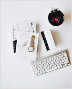 Vista cenital de un escritorio minimalista con cuadernos, reloj, regla y teclado preparado para usar etiquetas fantastical organizar eventos