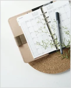 Agenda abierta con calendario, bolígrafo y plantas para usar rescuetime mejorar tus habitos trabajo