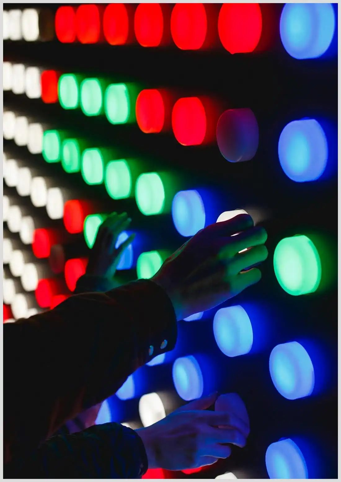 Manos tocando un panel de botones luminosos multicolores para usar zoom webinars interactivos